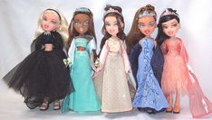 six dolls are lined up in dresses and tiaras for a photo shoot on a white background