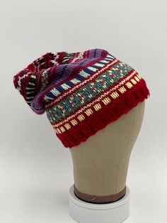 This listing is for a beautiful one-of-a-kind, hand-knit Fair-Isle style hat, size Adult.  It is made from an assortment of high-quality wool, acrylic, cotton and/or nylon worsted-weight yarns from Cascade, Berocco, Lambspride and other quality American and European spinners. Colors are chosen from a stock of over 50 different colors, resulting in a complex combination of color shades and patterns. Each hat is hand-knit using American size 6 (ribbing) and 7 (body) circular needles, resulting in Winter Hand Knitted Fitted Hat, Warm Acrylic Bonnet, One Size Fits Most, Adjustable Knit Cap, Warm Acrylic Bonnet One Size Fits Most, Warm Acrylic Bonnet One Size, Warm Acrylic Bonnet, Red Beanie Hat, One Size Fits Most, Adjustable Knit Beanie Hat, Knitted Bonnet For Cold Weather, One Size