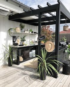 an outdoor patio with potted plants and hats on the shelves, along with other items