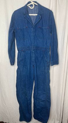 This jumpsuit is good used condition. There are some stains on the garment (pictured) and a few small holes. If you have any questions please feel free to ask. Flat Lay Measurements: Chest: 23 inches Shoulder: 18 inches Waist: 17 inches Hip: 20 inches Inseam: 29 inches Length: 59 inches Vintage Washed Cotton Overalls, Vintage Medium Wash Overalls, Vintage Dark Wash Overalls, Vintage Dark Wash Cotton Denim Jumpsuit, Vintage Medium Wash Washed Overalls, Vintage Medium Wash Overalls With Pockets, Vintage Dark Wash Overalls With Pockets, Vintage Blue Shortalls, Vintage Cotton Medium Wash Shortalls