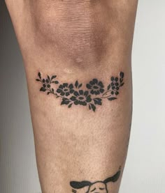 a tattoo on the leg of a man with flowers and a dog's head