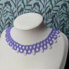 Lovely detailed beaded necklace - in purple-lined aqua and white pearlescent flowers. Every single one is handmade with love in New Jersey, U.S.A. Created with quality Czech beads, and premium Japanese seed beads. Significantly less bead de-coloration than cheap coated beads. This necklace gives the illusion of lace and vines, and would make a perfect 3rd wedding anniversary present (glass). Adjustable length: 15-18 inches. Stainless-steel alloy spring closure. Care: Please keep out of water, pe Handmade Purple Beaded Necklace For Weddings, Handmade Lavender Beads For Gifts, Handmade Lavender Beaded Necklaces With Round Beads, Purple Round Beads Pearl Necklace For Gift, Purple Beaded Pearl Necklace, Handmade Purple Pearl Necklace With Round Beads, Adjustable Beaded Purple Pearl Necklace, Adjustable Purple Beaded Pearl Necklace, Handmade Purple Pearl Necklace For Gift