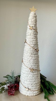 a white crocheted christmas tree with gold stars