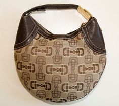 A Gucci mini hobo handbag.  The bag is made of brown and beige canvas with a horse-bit pattern, and it features brown leather trim and gold-tone hardware.  The interior is lined with brown fabric and next to the major compartment, it has one side pocket with a zipper. The bag has hardly any signs of use and it is in very good vintage condition. It will be delivered without a dust bag and cards. Measurements (cm & inch) Height: 19 cm / 7.5 inches Width (bottom): 12 cm / 4.75 inches Width (middle) Brown Shoulder Bag With Horsebit Detail, Brown Travel Bags With Horsebit Detail, Brown Horsebit Shoulder Bag, Brown Satchel Shoulder Bag With Horsebit Detail, Brown Shoulder Bag With Horsebit Detail For Everyday Use, Brown Horsebit Satchel Shoulder Bag, Brown Bags With Horsebit Detail For Everyday Use, Brown Office Shoulder Bag With Horsebit Detail, Brown Horsebit Detail Bag For Office