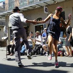 two people dancing in the street while others watch