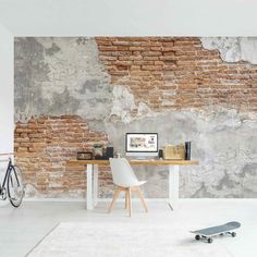 a skateboard is sitting on the floor in front of a brick wall and table