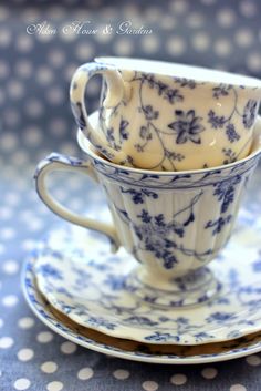 two cups and saucers are stacked on top of each other in blue and white