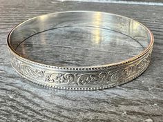 Brand new style! Beautiful botanical floral design, with a nice thick, sturdy weight.  Dimensions: .375" x .059"  I prefer to make all bangles to order in your exact size, so please allow up to 2 weeks to receive your order. I can also make any piece in a round or oval open cuff style so that it is fully adjustable. You can determine your bangle size in two ways: 1) You can measure the length around the widest part of your hand (circumference) or, 2) Measure the diameter (length from inside edge to inside edge of the circle) of an existing bangle. Method 1: Bring your thumb and pinky finger together. Use a piece of string or a measuring tape to measure around the widest part of your hand (where the bangle would have to slide over), and provide that measurement to me in inches or millimeter Pinky Finger, Antique Silver Jewelry, Sterling Silver Bangle, Botanical Pattern, Sterling Silver Bangles, Silver Bangle, Measuring Tape, Silver Bangles, New Style