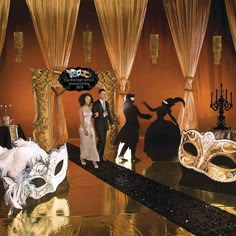 a group of people standing next to each other in front of masquerade masks