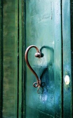 a heart shaped handle on a green door