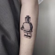 a black and white photo of a robot tattoo on the arm