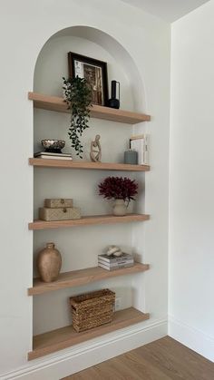 the shelves in the room are empty except for books and vases to be placed on