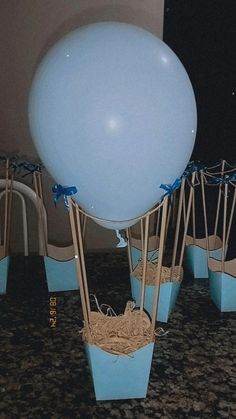 a bunch of balloons that are sitting in some blue pots on the ground with string