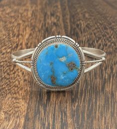 This Native American handmade cuff bracelet showcases a beautiful Kingman turquoise stone set in sterling silver. The intricate design is a testament to the artisan, Dave Skeets, and the Navajo tribal affiliation. The piece is expertly crafted and signed by the artist, making it a unique and valuable addition to any jewelry collection. The nature-themed bracelet is unisex, perfect for anyone to wear. Native American sterling silver Navajo handmade kingman turquoise cuff bracelet Weighs: 30 grams Bracelet size: 5 1/2 Opening size: 1 Width: 1 1/2 THANK YOU FOR YOUR BUSINESS, IF YOU HAVE ANY QUESTIONS PLEASE LET ME KNOW :)  ALSO IF YOU ARE LOOKING FOR A PARTICULAR ITEM PLEASE LET ME KNOW! Western Style Blue Bangle Jewelry, Bohemian Oval Sterling Silver Bracelet, Western Sterling Silver Cuff Bracelet Gift, Western Style Bangle Jewelry As Gift, Western Style Bangle As Gift, Western Style Bangle Jewelry Gift, Bohemian Sterling Silver Oval Cuff Bracelet, Southwestern Style Turquoise Cuff Bracelet, Southwestern Style Round Turquoise Cuff Bracelet