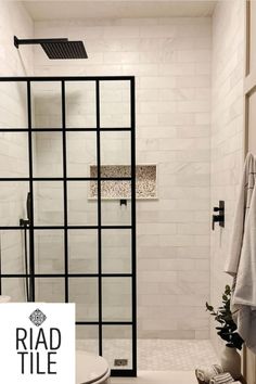 a white tiled bathroom with black accents