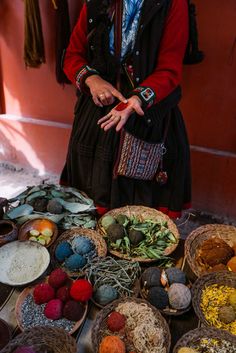 a woman standing in front of baskets filled with food