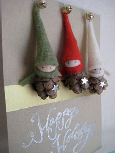 two little gnomes are hanging on the side of a card that says happy holidays