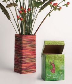 a vase with flowers in it next to a box