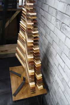 a pile of wood sitting on top of a wooden table next to a brick wall