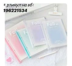 four notebooks sitting next to each other on top of a white sheet with the words fall in russian