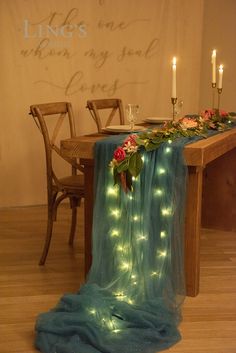 a long table with lights on it and some chairs in front of the table is covered by a blue cloth