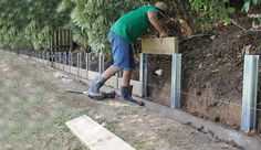 a man is working on the side of a fence