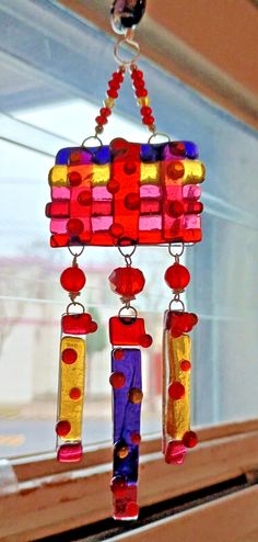 a colorful wind chime hanging from a window