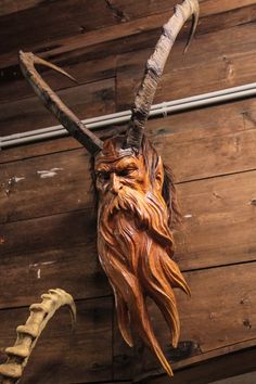 an animal head hanging on the side of a wooden wall