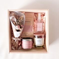 an open box containing candles, body care products and flowers