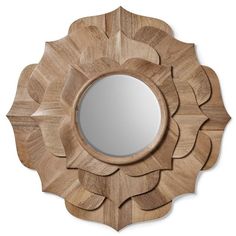 a wooden mirror sitting on top of a white wall