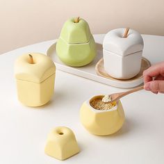 a white table topped with bowls and containers filled with food next to an apple on top of a plate