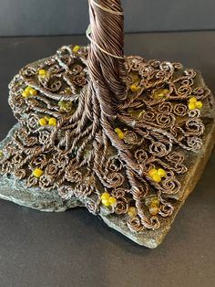 a wire tree sculpture sitting on top of a rock