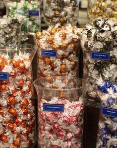 there are many different types of candies in plastic containers on the shelf at the store