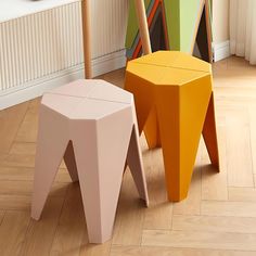 two colorful stools sitting next to each other on the floor