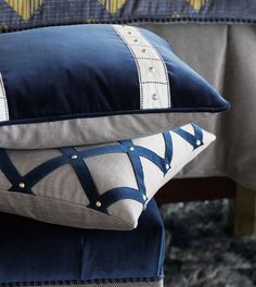 two blue and white pillows stacked on top of each other