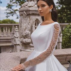 a woman in a white dress posing for the camera with her hands on her hips