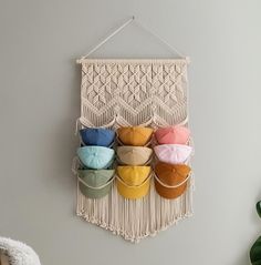 a macrame hanging on the wall with several pairs of slippers