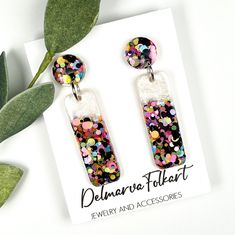 the earrings are decorated with multicolored confetti and sequins on them