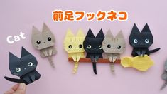 a hand is holding an origami cat with four cats on it and the other one has eyes