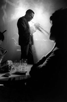 black and white photograph of two men talking to each other in front of a microphone