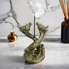 a dragon incense burner sitting on top of a table next to a candle holder