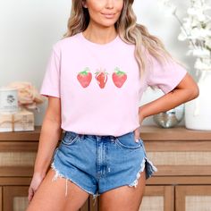 Add sweetness to your wardrobe with our Kawaii Strawberry Shirt--cute, fun, and perfect for everyday wear! IMPORTANT INFORMATION - DTG printing - 100% preshrunk cotton - Wash and dry normally (on cool for best results) - Do not bleach - Tumble dry: low heat; - Do not dryclean * S I Z I N G * - Models are wearing size small (some photos tee is knotted to the side, but it is sent untied, regular length) - Sizing is unisex so runs like men's, though not overly large - Most women find their typical size works best, since they are meant to fit a touch loose * S H I P P I N G * T I M E S * - Our items are individually made with love for each of our buyers. Because of this, our processing time is 3-7 business days (depending on order volume) plus transit time, but typically much faster. We know o Coquette Tshirt, Strawberry Tshirt, Clothes Coquette, Clothing Coquette, Coquette Clothes, Coquette Top, Coquette Clothing, Kawaii Strawberry, Coquette Shirt