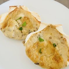 two scallop shells on a white plate