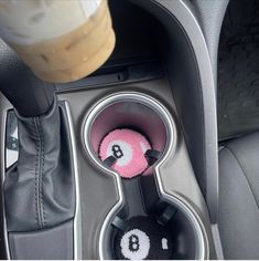 the interior of a car with two balls and a cup holder in front of it