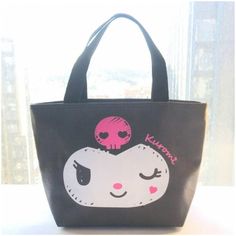 a black and white bag with a pink skull on it's face is sitting in front of a window