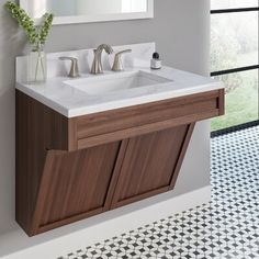 a bathroom with a sink, mirror and tiled flooring in white and brown colors