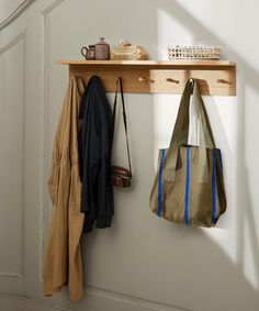 a wooden shelf with two bags hanging from it