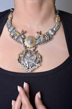 Bring the royal elegance of Rajasthan on your neck with this Marwar collection in silver and golden dual-tone metal collar necklace set with an animal (blackbuck) motif to make it more natural and connected to the earth. The matching earrings complete the aura of the set. The penny is kept aside to make you understand the real size of the object.