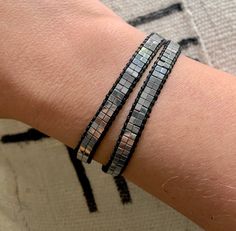 Add interest and style to any outfit with this eye-catching wrap bracelet. Features Silver Hematite Gemstone Beads with lots of sheen. Easily wraps around the wrist twice with a silver button closure. Several button holes for a customized fit on any wrist. No guesswork on sizing, making this a great gift! Total length is 17 inches. {Hematite is a natural gemstone with a metallic look and feel} Elegant Silver Wrap Bracelet With Faceted Beads, Bohemian Silver Wrap Bracelet With Faceted Beads, Silver Wrap Bracelet With Faceted Beads, Bohemian Silver Wrap Bracelet With Spacer Beads, Adjustable Hematite Jewelry With Silver Beads, Silver Beaded Wrap Bracelet For Festivals, Adjustable Silver Modern Beaded Bracelets, Modern Adjustable Beaded Bracelets For Party, Adjustable Hematite Bracelet With Silver Beads