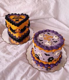 two decorated cakes sitting on top of a white table